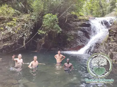 a group of men in the water in front of a waterfall at Casona La Vieja, Luz del Corazón in Rincón de la Cruz