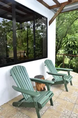 two green lawn chairs sitting on a patio at Casa Curré Monteverde in Monteverde Costa Rica