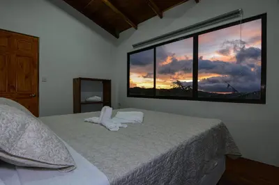 a bedroom with a bed and a large window at Casa Curré Monteverde in Monteverde Costa Rica