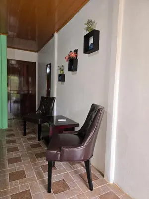 a waiting room with two chairs and a table at Tortuguero Hill Rooms in Tortuguero