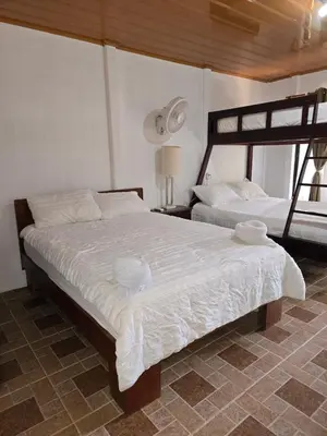 a bedroom with two beds with white sheets at Tortuguero Hill Rooms in Tortuguero