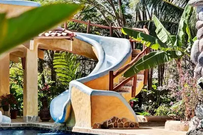 a water slide in a backyard with a pool at Stunning House! Villa Kalapiti - Blue Zone Costa Rica in Delicias