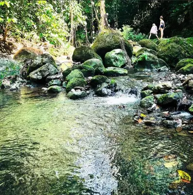 two people standing on rocks near a stream of water at Stunning House! Villa Kalapiti - Blue Zone Costa Rica in Delicias