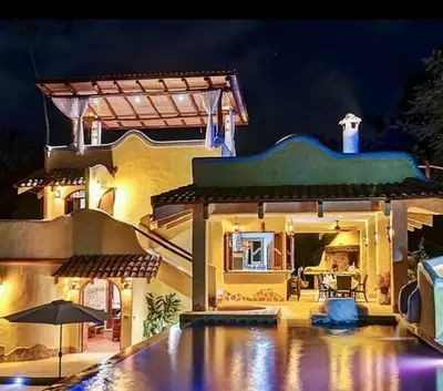 a large house with a swimming pool at night at Stunning House! Villa Kalapiti - Blue Zone Costa Rica in Delicias