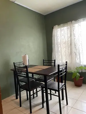 a dining room table with chairs and a window at Big Sloth Apartment in Fortuna