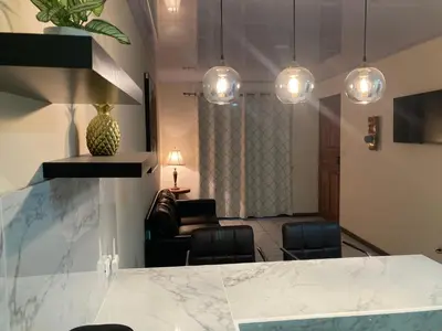 a lobby with chairs and a table and lights at Hospedaje Ana Lu 1 Only 10 minutes from airport in Alajuela City