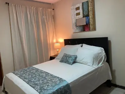 a bedroom with a bed with a pillow and a window at Hospedaje Ana Lu 1 Only 10 minutes from airport in Alajuela City