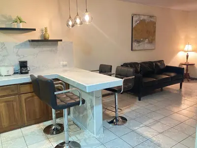 a kitchen and living room with a table and chairs at Hospedaje Ana Lu 1 Only 10 minutes from airport in Alajuela City