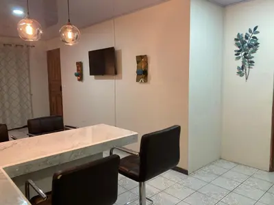 a meeting room with chairs and a table and a tv at Hospedaje Ana Lu 1 Only 10 minutes from airport in Alajuela City