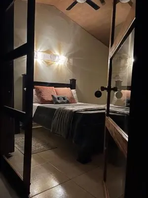 a bedroom with a bed in a room with a mirror at Siquirres Mountain Lodge in Siquirres