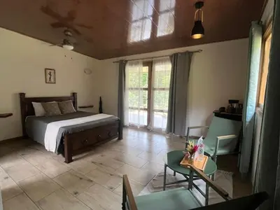 a bedroom with a bed and a table and chairs at Siquirres Mountain Lodge in Siquirres