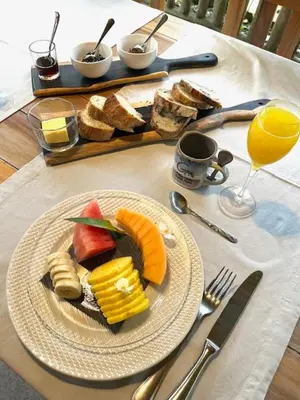 a plate of fruit and bread on a table at Siquirres Mountain Lodge in Siquirres