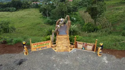 a playground with a slide in a park at Hotel Heliconias Nature Inn & Hot Springs in Fortuna