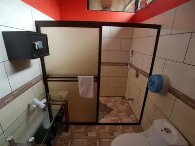 a bathroom with a shower and a toilet in it at Hotel Heliconias Nature Inn & Hot Springs in Fortuna
