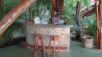 a stone fireplace with two stools in front of it at Nosara Sunrise Bed and Breakfast in Nosara