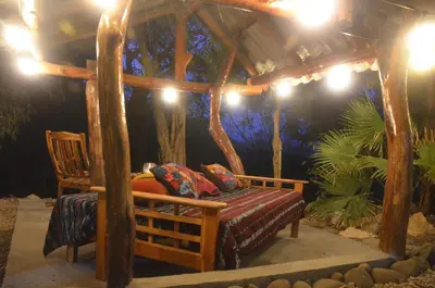 a bed in a wooden gazebo with lights at Nosara Sunrise Bed and Breakfast in Nosara