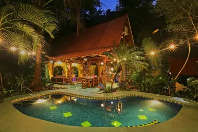 a swimming pool in front of a house at night at Nosara Sunrise Bed and Breakfast in Nosara