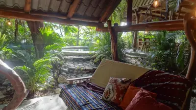 a living room with a couch in a garden at Nosara Sunrise Bed and Breakfast in Nosara