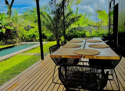 a wooden deck with a table and chairs next to a pool at Cabaña Grande océan and jungle Infinity swim pool in Santa Teresa Beach