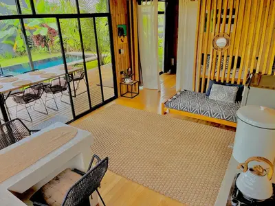 a living room with a table and a couch at Cabaña Grande océan and jungle Infinity swim pool in Santa Teresa Beach