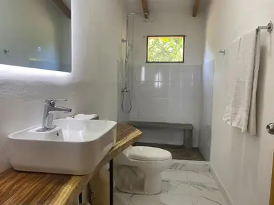 a white bathroom with a sink and a toilet at La casa del Artesano !Casa completa frente al mar! in Santa Cruz