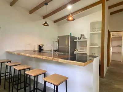 a kitchen with a counter and some stools at La casa del Artesano !Casa completa frente al mar! in Santa Cruz