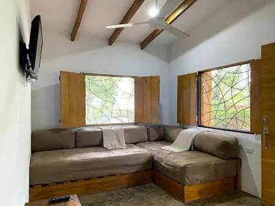 a living room with a couch and two windows at La casa del Artesano !Casa completa frente al mar! in Santa Cruz