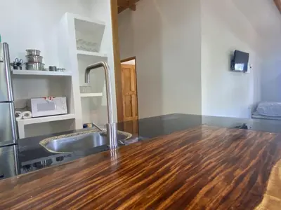 a kitchen with a sink and a wooden floor at La casa del Artesano !Casa completa frente al mar! in Santa Cruz