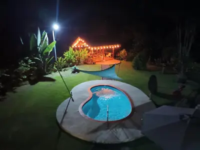 a backyard with a swimming pool at night at Yethan house in Uvita
