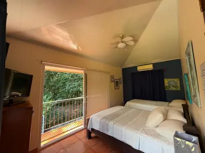 a bedroom with a bed and a large window at Yethan house in Uvita