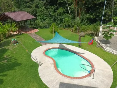 a backyard with a swimming pool and a gazebo at Yethan house in Uvita