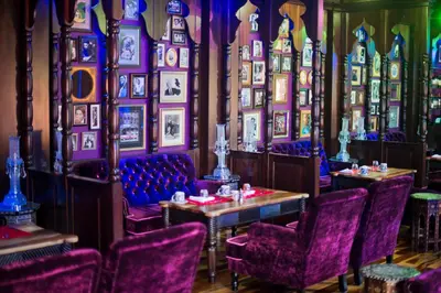 a dining room with purple chairs and pictures on the walls at Nayara Springs - Adults Only in Fortuna