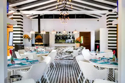 a dining room with white tables and white chairs at Nayara Springs - Adults Only in Fortuna