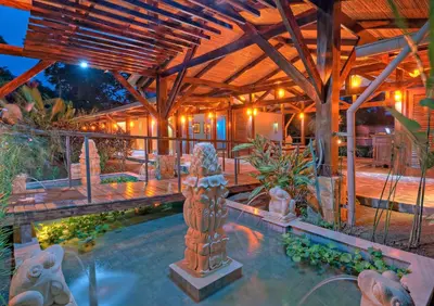 a house with a swimming pool with a wooden ceiling at Nayara Springs - Adults Only in Fortuna