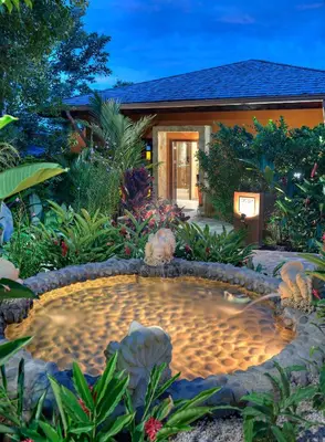 a garden with a pond in front of a house at Nayara Springs - Adults Only in Fortuna