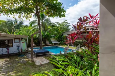 a villa with a swimming pool in a garden at Maoritsio Garden Studios in Santa Teresa Beach