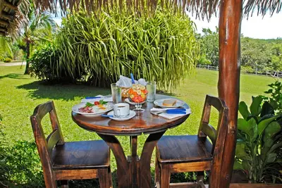 a wooden table with a plate of food on it at Guacamaya Lodge in Paraíso