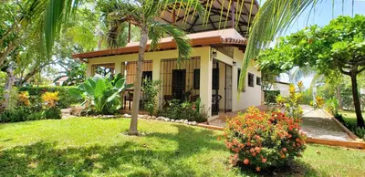 a house with a palm tree in a yard at Guacamaya Lodge in Paraíso