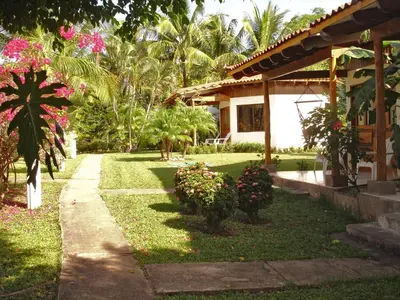 a house with a garden with pink flowers in the yard at Guacamaya Lodge in Paraíso