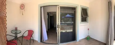 a room with a glass door with a table and chairs at Lovely studio-apartment near the beach in Uvita