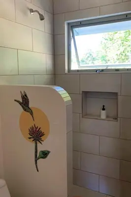a bathroom with a flower painted on the side of a tub at Lovely studio-apartment near the beach in Uvita