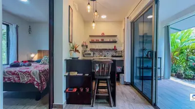a room with a bed and a kitchen with a counter at Lovely studio-apartment near the beach in Uvita