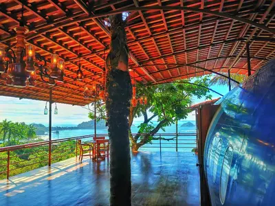 a building with a tree and a table and chairs at Hotel Costa Verde in Manuel Antonio