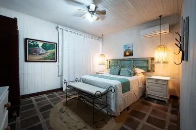 a bedroom with a bed and a chair in it at Hotel Punta Descartes in La Cruz