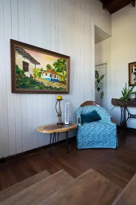 a living room with a table and a couch and a painting at Hotel Punta Descartes in La Cruz