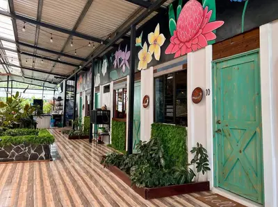 a building with green doors and flowers on the wall at Tucan Hotel in Uvita