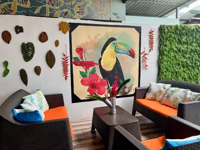 a seating area with a painting of a bird on a wall at Tucan Hotel in Uvita