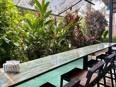 a wooden table and chairs in a garden at Tucan Hotel in Uvita