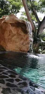 a water fountain next to a large rock at EcoVillas Las Melinas in Playa Avellana