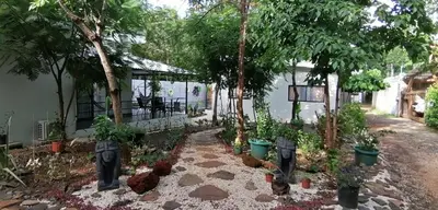a garden in front of a house with trees at EcoVillas Las Melinas in Playa Avellana